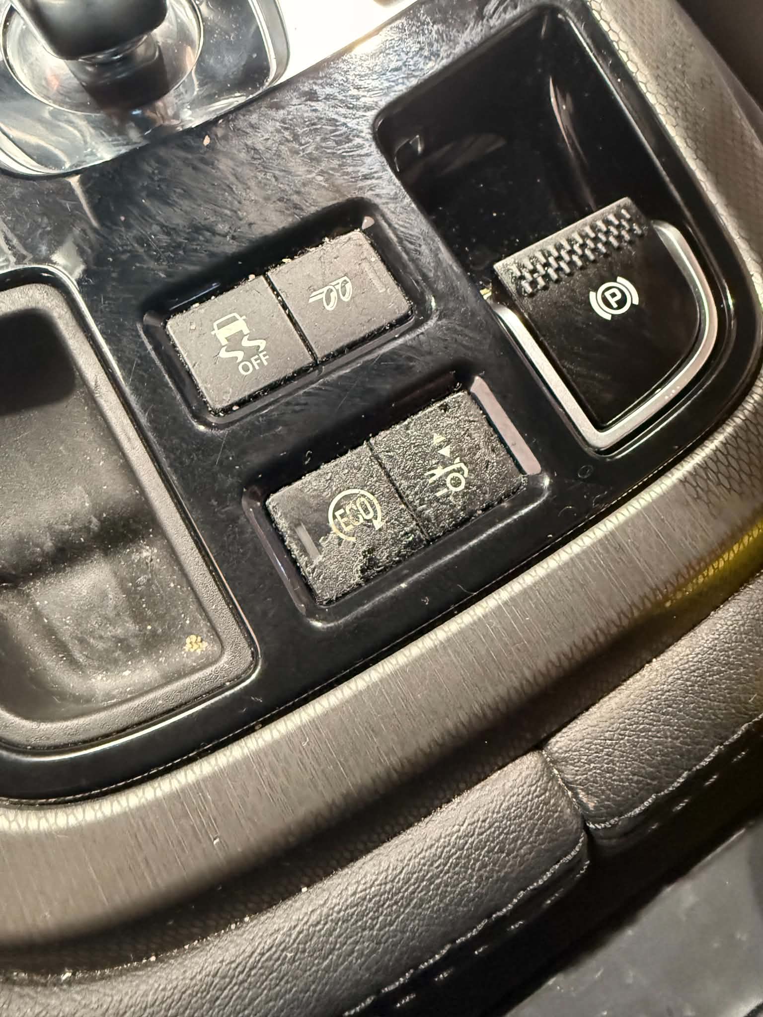 Console switch panel before restoration showing sticky, peeling soft touch coating and faded symbols
