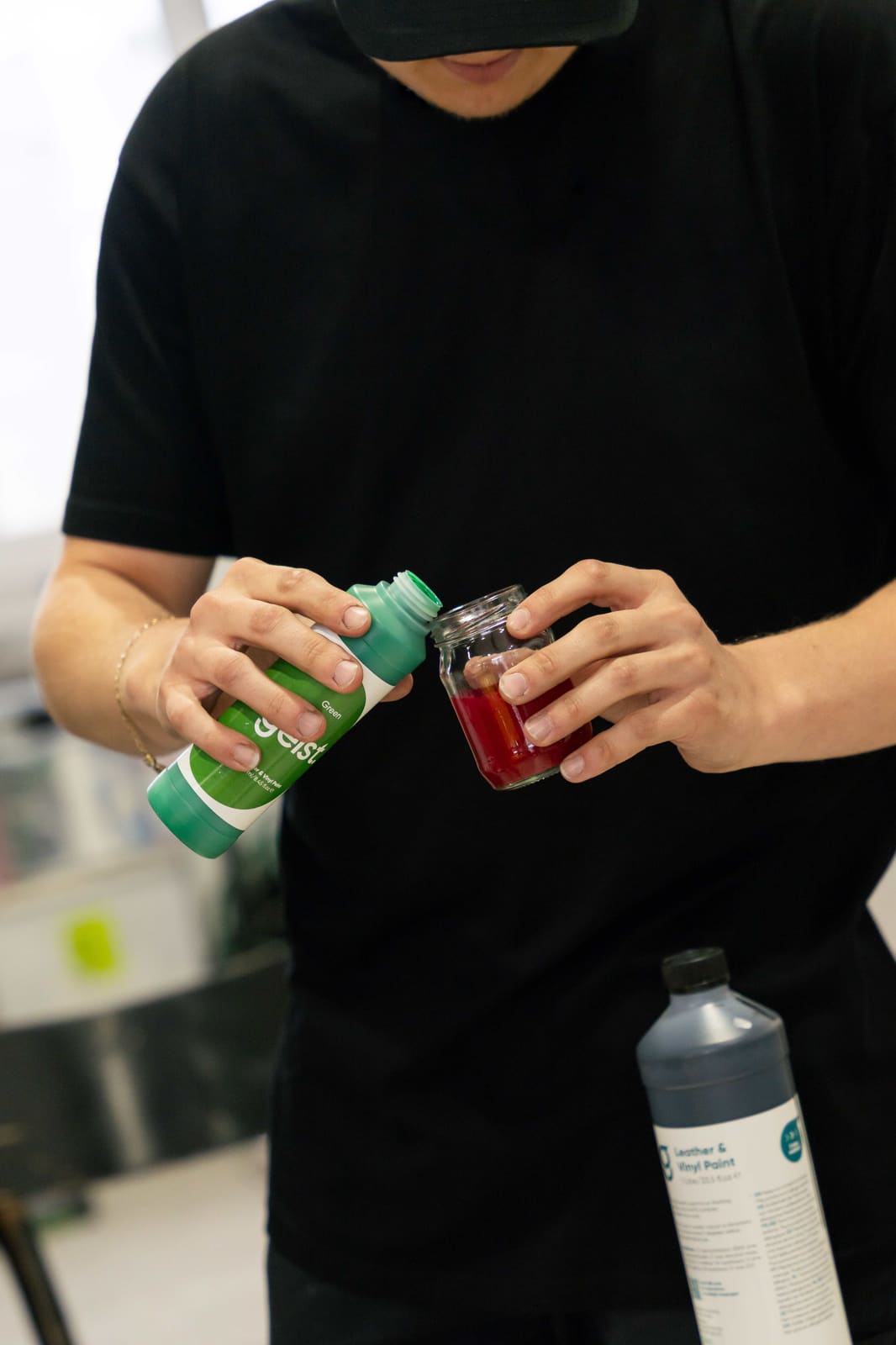 Trainer pouring green Geist leather and vinyl paint to mix a custom colour